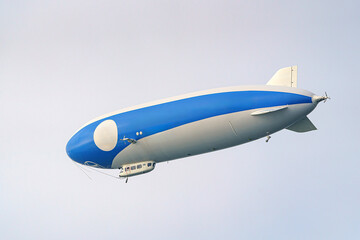 A tourist airship with passengers on board travels through the sky. © andov