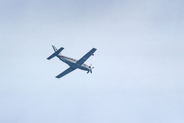 A plane with a propeller flies high in the sky.