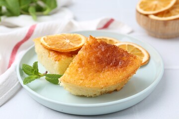Tasty semolina cake served on white tiled table, closeup