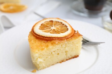 Slice of tasty semolina cake served on white table, closeup
