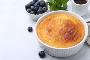 Tasty semolina cake served on white tiled table, closeup. Space for text