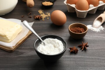 Baking powder and other products on grey wooden table, closeup