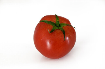 A fresh, ripe tomato resting on a pure white surface ready for culinary delights or garden inspiration