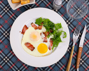 Delicious hearty breakfast with scrambled eggs, bacon and arugula