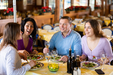 Group of friends enjoying evening meal at cozy restaurant