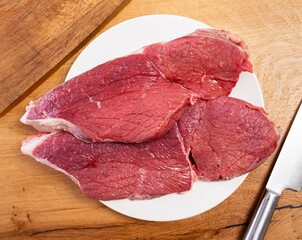 Raw beef veal meat tenderloin lie next to spices - process of cooking homemade festive dish. There...