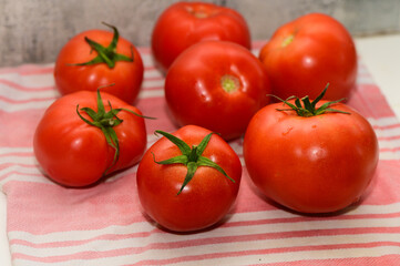 Freshly picked vibrant tomatoes arranged beautifully on a striped cloth in a cozy kitchen setting