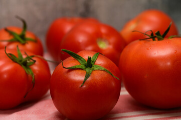 Freshly harvested ripe tomatoes on a rustic kitchen table setting ready for culinary delights