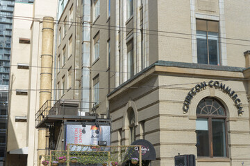 Fototapeta premium exterior building facade and sign of Cubecom Commercial Realty Inc, including Charlotte's Room. and a billboard for imported beer in downtown Toronto, Canada