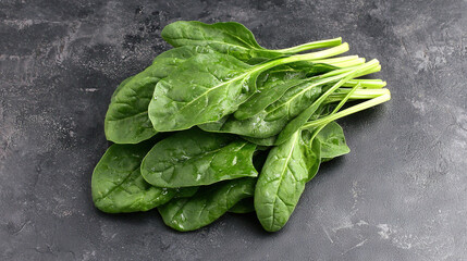  A pile of fresh spinach rests atop a table, alongside an assortment of chopped green veggies