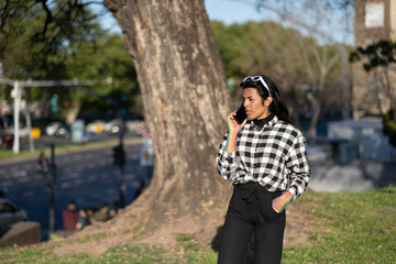 Transgender woman talking on cell phone in a park