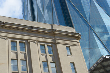 Fototapeta premium contrast of historic building clad in stone and the diamantine exterior window patterns of CIBC Square in downtown Toronto, Canada