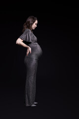 Portrait of young pregnant female in grey sequin dress.