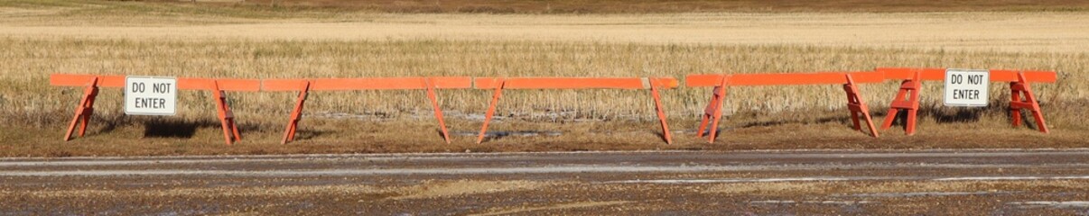 A long row of barricades with signs that say, 