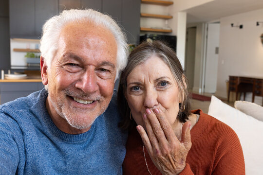 Happy senior couple at home, smiling and enjoying festive holiday moments, on video call