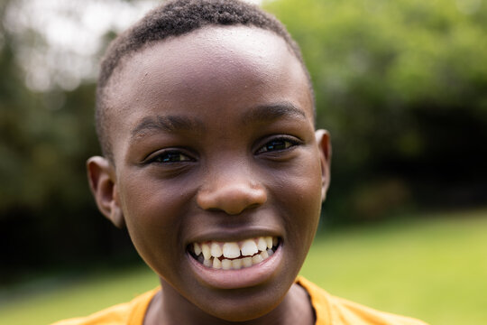Smiling boy enjoying outdoor time in sunny garden, feeling joyful and carefree