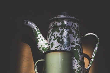 Vintage Enamel Teapot and Mug in Dramatic Lighting