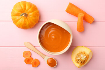 Delicious baby food in bowl and fresh ingredients on pink wooden table, flat lay