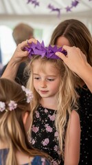 Naklejka premium A young girl is getting a purple crown placed on her head by a woman. AI.