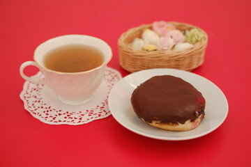 donut and cup of tea on the red table