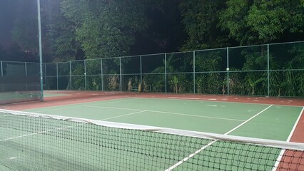 A photo of outdoor tennis court with white line and net