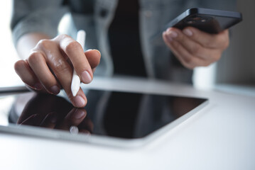 Multitasking business woman using digital tablet and mobile phone, busy working at office, reading e-document, closeup. Student online studying via tablet pc on table