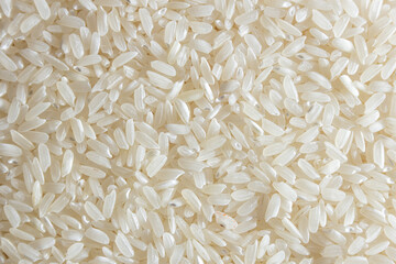 Dry Uncooked White Rice Background - Top View, Flat Lay. Scattered Raw Long Grain Rice. Asian Cuisine and Culture. Healthy Eating Ingredients. Diet Food