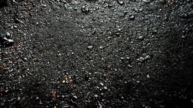 This is a close-up image of a rocky, dark surface, possibly taken on a planet or moon