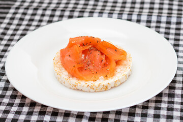 Tasty Rice Cake Sandwich with Fresh Salmon Slices on White Plate. Easy Breakfast and Diet Food. Crispbread with Red Fish. Healthy Dietary Snack