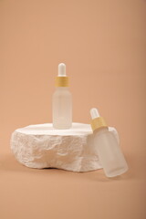 Frosted Glass Dropper Bottles with Yellow Caps on Natural Stone and Neutral Background