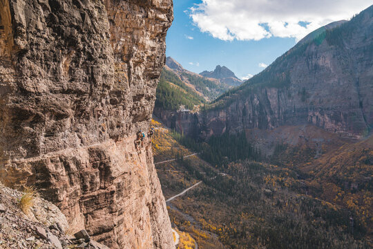 Group traversing a Via Ferrata over a steep cliff
