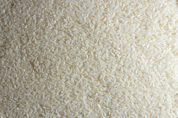Dry Uncooked White Rice Background - Top View, Flat Lay. Scattered Raw Long Grain Rice. Asian Cuisine and Culture. Healthy Eating Ingredients. Diet Food