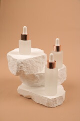 Frosted Glass Serum Dropper Bottles on White Stone Sculpture