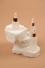 Frosted Glass Serum Dropper Bottles on White Stone Sculpture