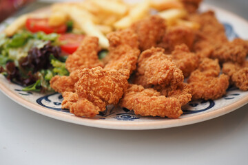 Indulge in Delicious Crispy Fried Chicken served alongside French Fries and a Fresh Salad