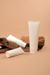 White Cosmetic Tubes with Wooden Accents on Neutral Beige Background