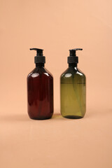 Collection of Amber and Green Pump Bottles with Wooden Decor on Beige Background