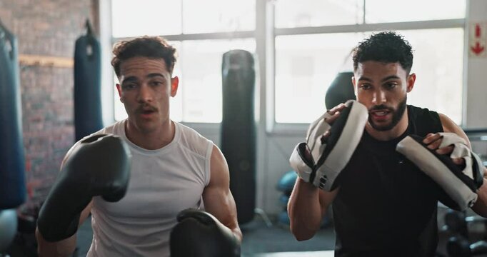 Athlete, boxing and coaching in gym for fitness, exercise and learning with help, workout and training. Men, boxer and personal trainer for sports, teamwork and growth with martial arts and fight