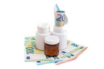 Different Bottles with Pills, Capsules and Medicines on the Euro Banknotes - Isolated on White. Global Pharmaceutical Industry and Big Pharma. Euro Money Bills - Isolation