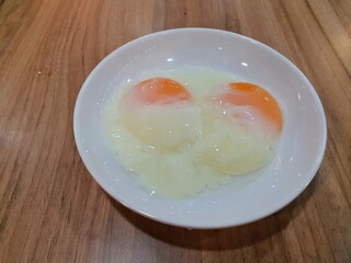 Half Boiled Chicken Egg served on a round white plate
