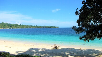 Blue sky day in Pasir Putih Manokwari, Papua, Indonesia. A beautiful quiet beach, only the sound of wave is heard, bright blue sky, full of memory