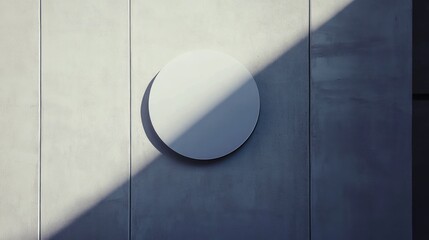 A blank circular sign on a concrete wall with a diagonal shadow.