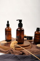 Amber Glass Skincare Bottles and Pump Dispensers on Wooden Tray with Candles