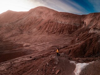 Vertical shot of a woman watching the scenery of San Pedro de Atacama desert at sunset, Chile