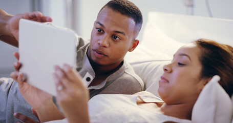 Tablet, relax and couple on bed in home choosing movie, film or show for streaming online together. Love, rest and young man and woman with digital technology for browsing social media in bedroom.