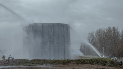 Cooling of a burning oil tank with the help of hydraulic monitors . A fire in a tank for storing...