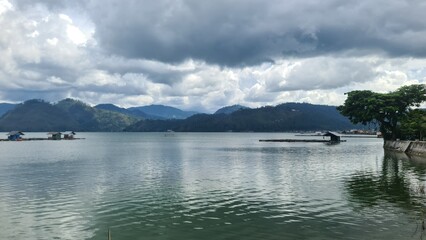 Serene Lake with Cloudy Sky and Green Hills