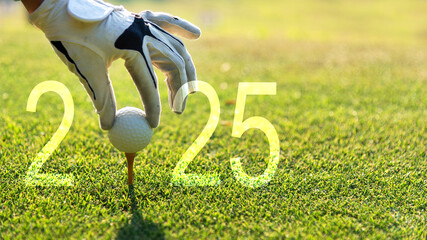 Close up hand Golfer woman putting golf ball for Happy New Year 2025 on the green golf for new...