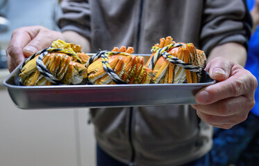 Man’s hands holding the plate full of crabs. Delicious Yangcheng lake crabs for family dinner.