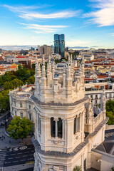 Neoclassical style stone towers in the Madrid city hall building and view of the capital in the background, Spain.
